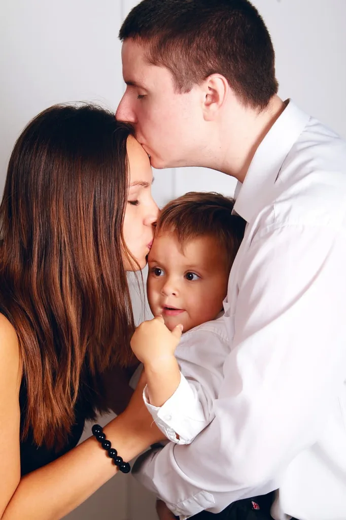 Familia con padre, madre e hijo besándose